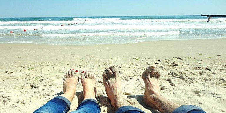 2 expats enjoying the beach feet in the sand